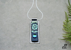 Fused Glass Blue and Green Dichroic Rectangular Pendant Etched with Mandala Designs on a Black/Clear base Fused Glass Blue and Green Dichroic Rectangular Pendant Etched with Mandala Designs on a Black/Clear base